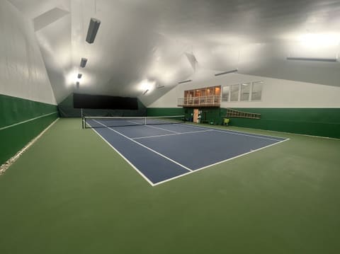 Court 1 from a back corner, with the lit viewing balcony and a row of windows above the far wall.