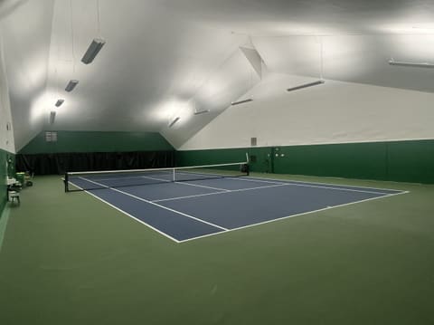 Court 3 from a corner, with a ball basket and a small bench along the left wall.
